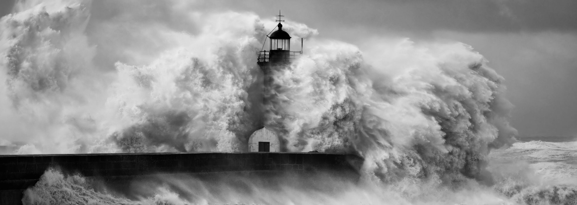 Image of lighthouse being hit by large waves in storm