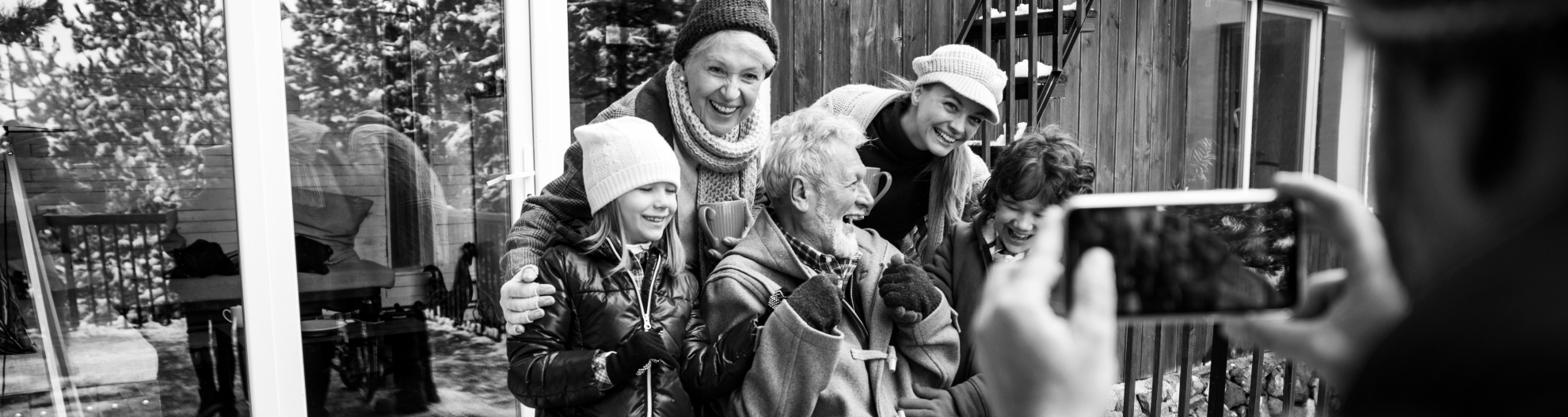 Multigenerational family posing for photo in front of house